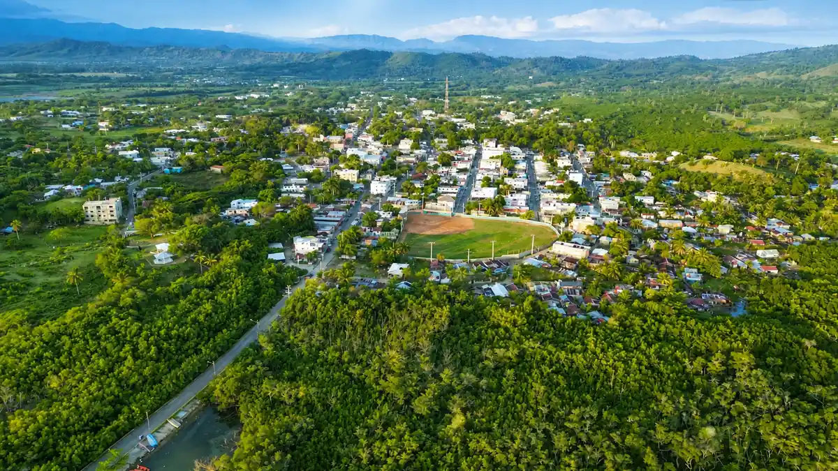 Aerial view of Luperón town with the central baseball field and surrounding green landscape.